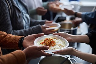 Ein Teller Suppe wird gereicht