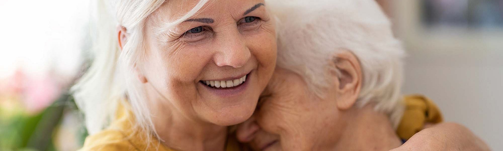 Eine Frau hält eine ältere Frau im Arm