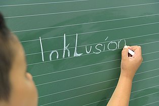 EIn Kind schreibt Inklusion an eine Tafel